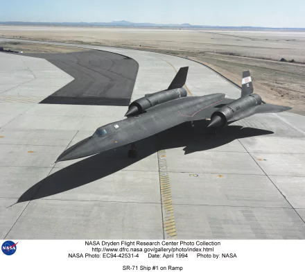 HD desktop wallpaper of a Lockheed SR-71 Blackbird military aircraft parked on a runway, showcasing its sleek, stealthy design and dark matte finish.