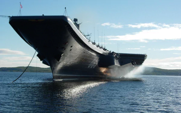 HD desktop wallpaper featuring the Russian aircraft carrier Admiral Kuznetsov, a powerful military warship, cruising through calm waters under a clear sky.