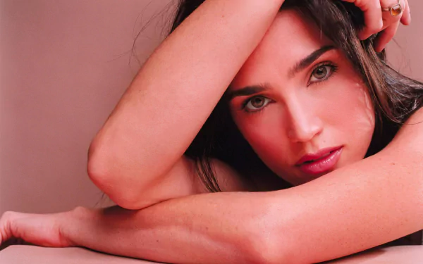 HD PC desktop wallpaper featuring a close-up portrait of celebrity Jennifer Connelly with a soft, pink-toned background and an elegant, contemplative pose.