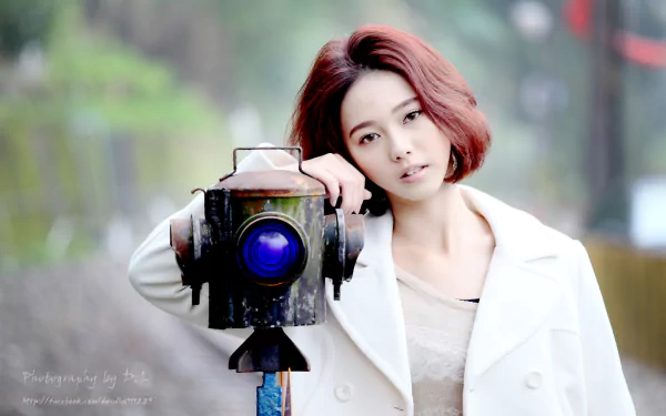 A Taiwanese woman poses next to a vintage traffic light with bokeh background. The image is tagged bokeh, traffic light, model, woman, and Lín Yǔ. This high-definition photo serves as a wallpaper or background.