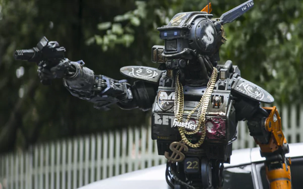 HD desktop wallpaper featuring Chappie, the robot character with gold chains, gesturing in front of a vehicle.