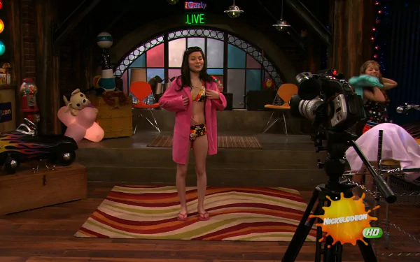 HD PC desktop wallpaper from the TV show iCarly (2007) featuring a behind-the-scenes studio setup with Carly standing center stage during a live recording.