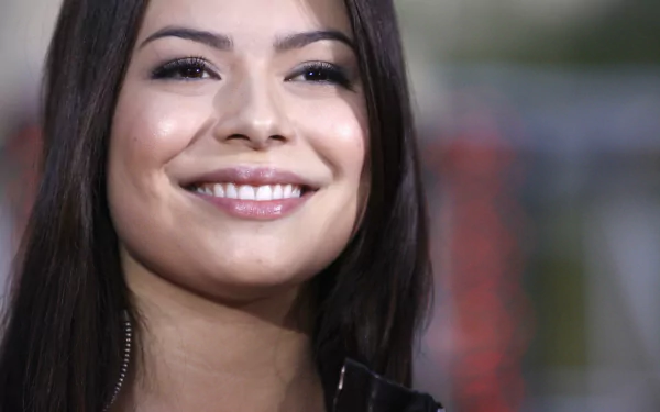 HD desktop wallpaper featuring a close-up of celebrity Miranda Cosgrove smiling with a blurred background.