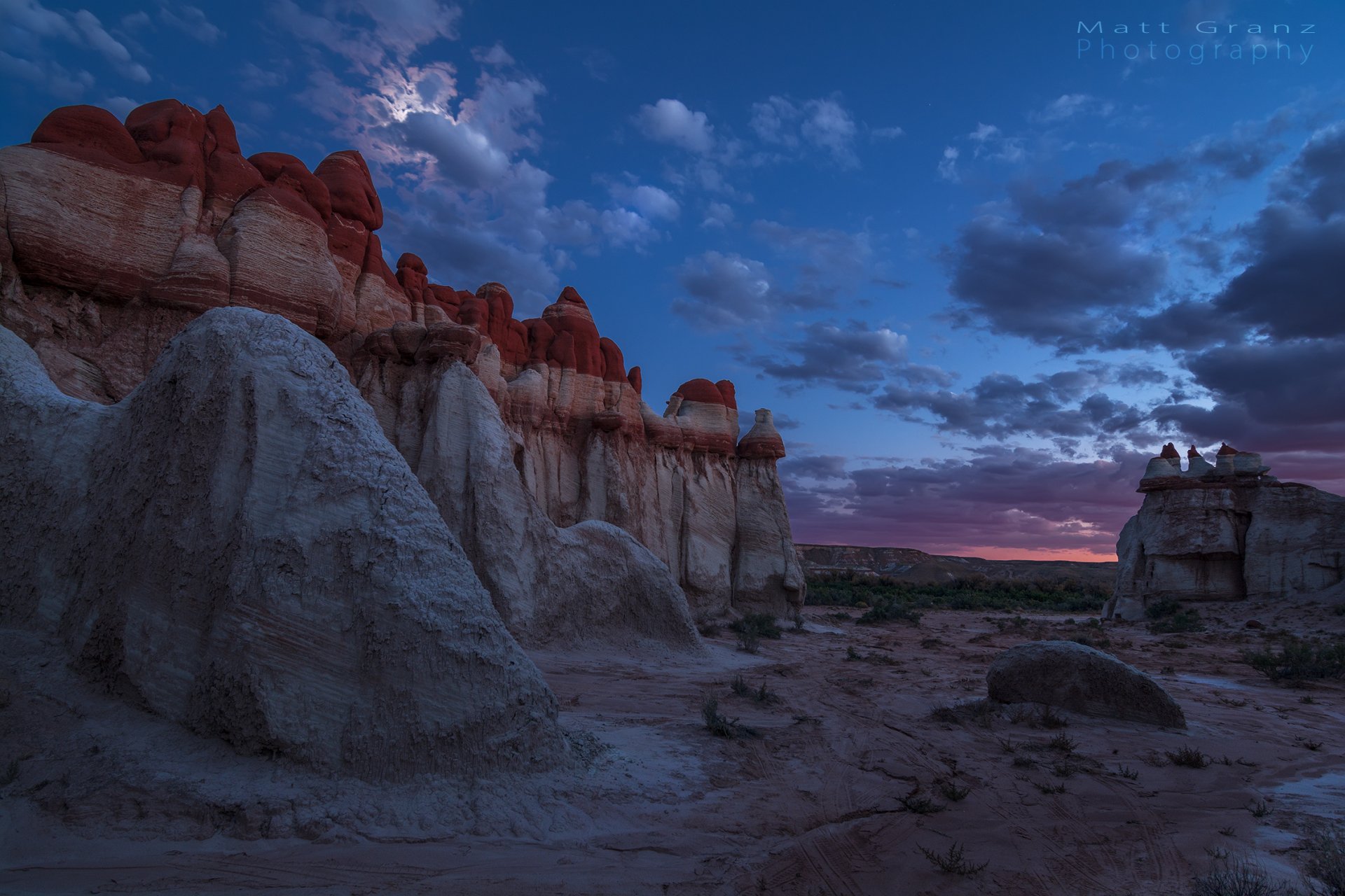 Twilight sky over California’s Blue Canyon with a glowing moon, scattered clouds, and striking rock formations in a serene natural landscape.