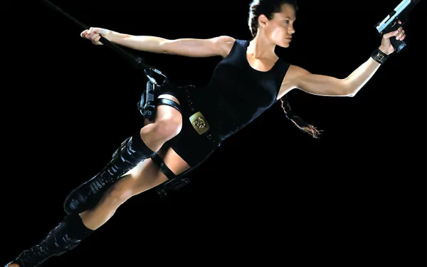 HD PC desktop wallpaper featuring Lara Croft from the movie Lara Croft: Tomb Raider in an action pose with a gun against a black background.