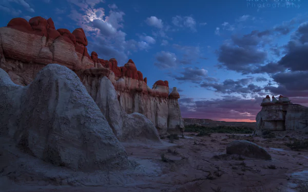 Twilight sky over California’s Blue Canyon with a glowing moon, scattered clouds, and striking rock formations in a serene natural landscape.