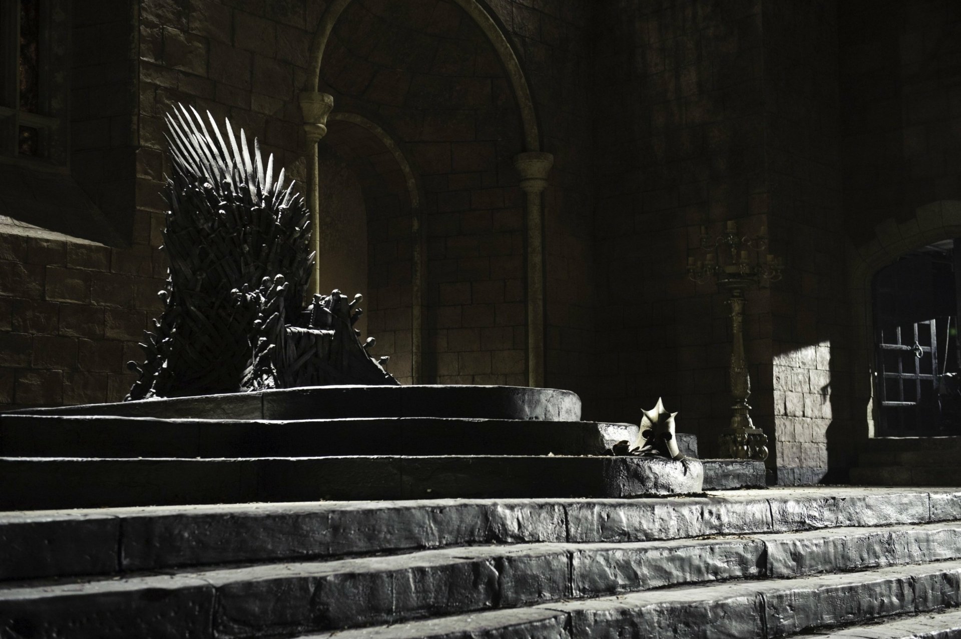 HD wallpaper featuring the Iron Throne from Game of Thrones, set in a dimly lit stone hall, emphasizing the iconic seat of power in the TV show.