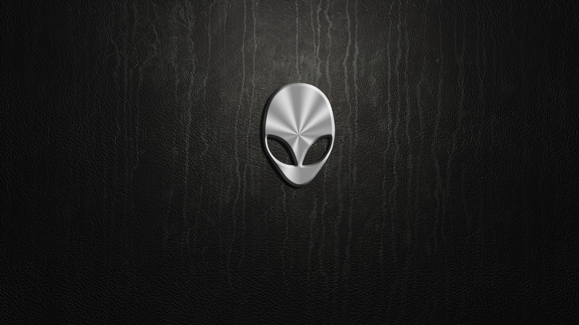 HD Alienware PC desktop wallpaper featuring a sleek metallic alien head emblem on a dark, textured technological background.