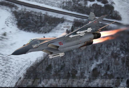 A Mikoyan MiG-29 military fighter jet soaring through the sky, showcasing powerful jet flames against a snowy landscape. High-definition wallpaper for aviation enthusiasts.