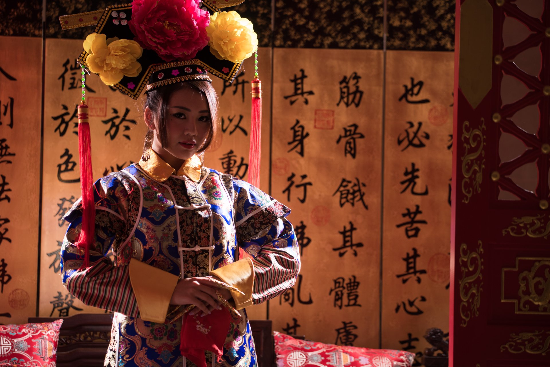 A Taiwanese woman dressed in traditional Chinese costume, portraying Qián Fūrén, set against a background of ancient calligraphy scrolls in this 4K Ultra HD desktop wallpaper.