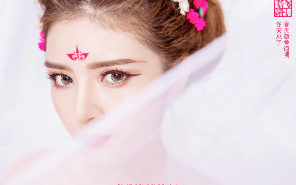 Close-up portrait of a Vietnamese woman, Lilly Luta, with traditional face decoration and soft pink floral accents, captured in 4K Ultra HD for a PC desktop wallpaper.