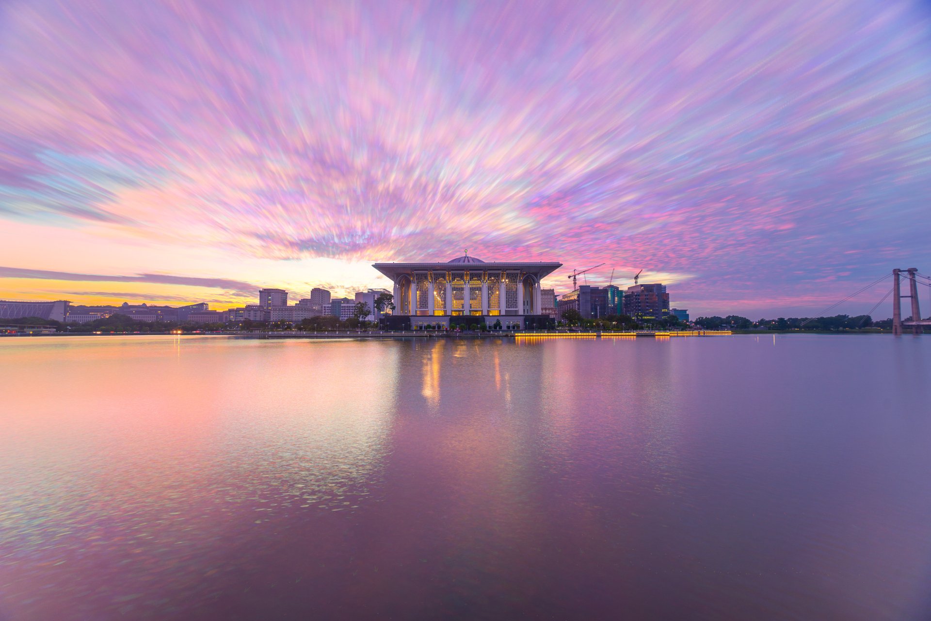 Sunrise over the Tuanku Mizan Zainal Abidin Mosque in Putrajaya, Malaysia, captured in vibrant 4K Ultra HD with serene water reflections and colorful sky.