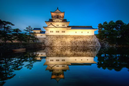Toyama Castle in Japan at twilight, beautifully reflected in the calm pond, captured in a stunning 4K Ultra HD desktop wallpaper.