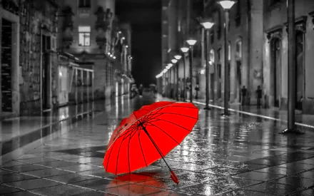 A vibrant red umbrella stands out against a monochromatic rain-soaked street, capturing a striking contrast in this HD photography wallpaper.