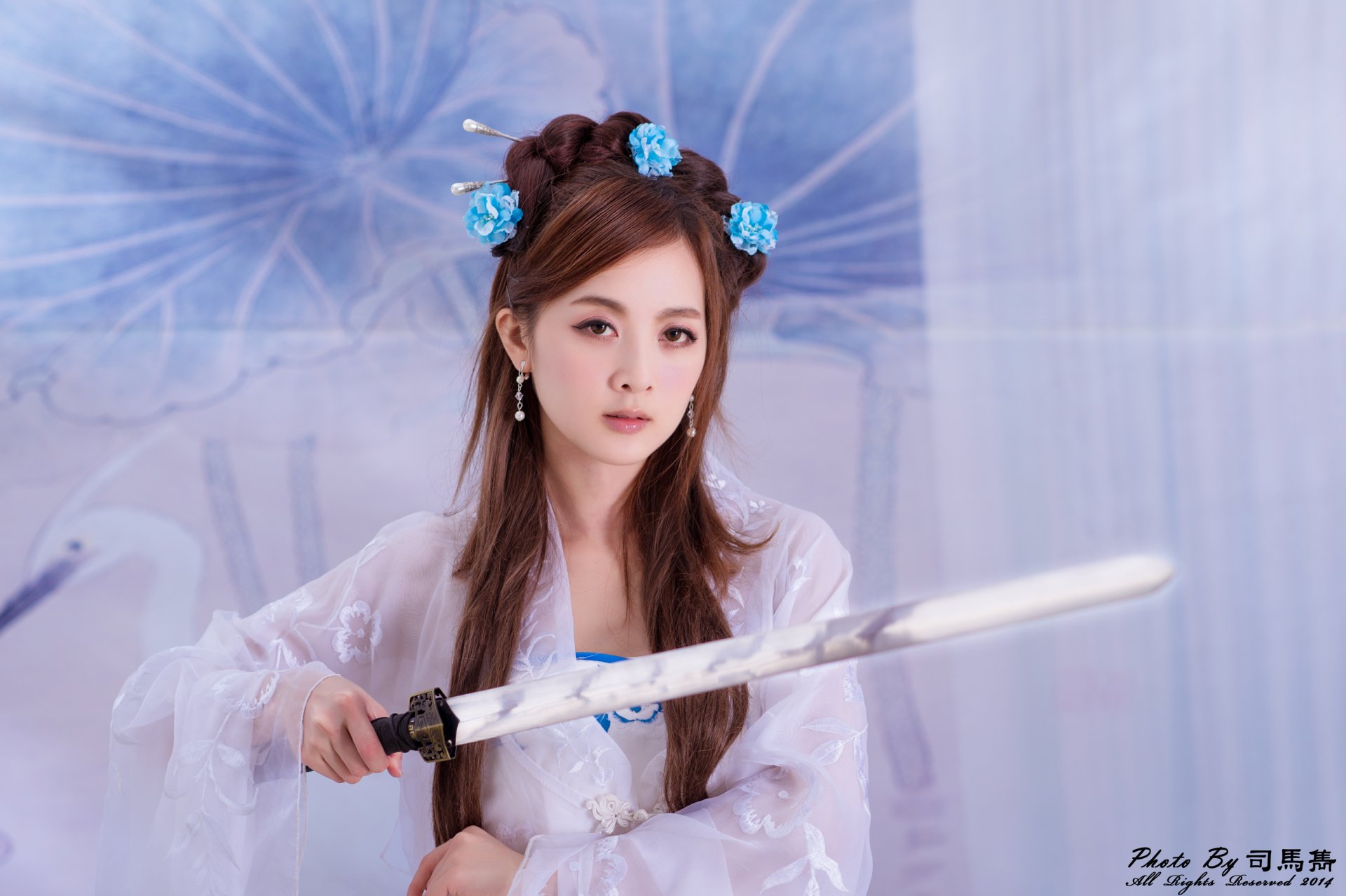 A Taiwanese woman in traditional Chinese costume with hairpins and an elaborate hair-dress holds a sword, captured in 4K Ultra HD as a striking PC desktop wallpaper.