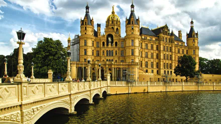 Schwerin Palace, a grand man-made landmark housing the Mecklenburg-Vorpommern Landtag in Germany, showcased with detailed architecture and a reflective water foreground.