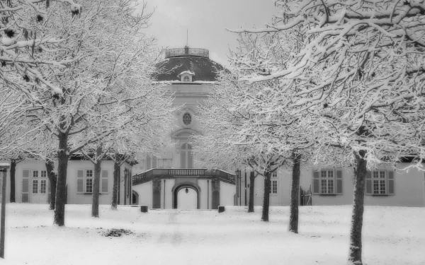 HD PC desktop wallpaper showing Castle Solitude, a man-made palace framed by leafless, snow-laden trees and a serene snowy courtyard.