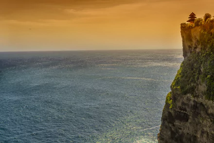 HD desktop wallpaper featuring a stunning ocean view at sunset from a high cliff in Ungasan, Bali, Indonesia. The seascape captures the vast, serene sea under a vibrant sky, epitomizing nature's beauty.
