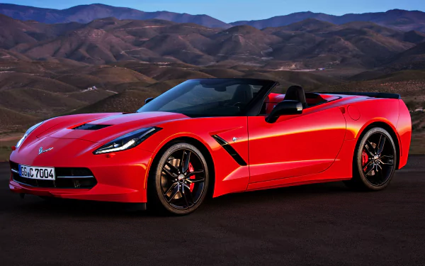 Red Chevrolet Corvette Stingray convertible on an open road with mountains at dusk — 4K Ultra HD PC desktop wallpaper showcasing the Chevrolet sports car.