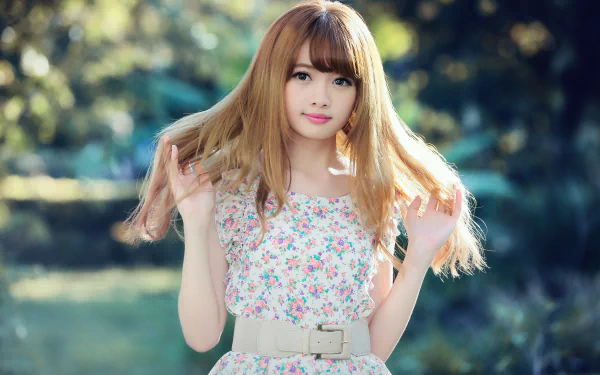 A Taiwanese model, Cubie Wang, poses in a floral dress with a belt, her hair flowing in a dreamy bokeh background, creating a vibrant, stylish portrait.