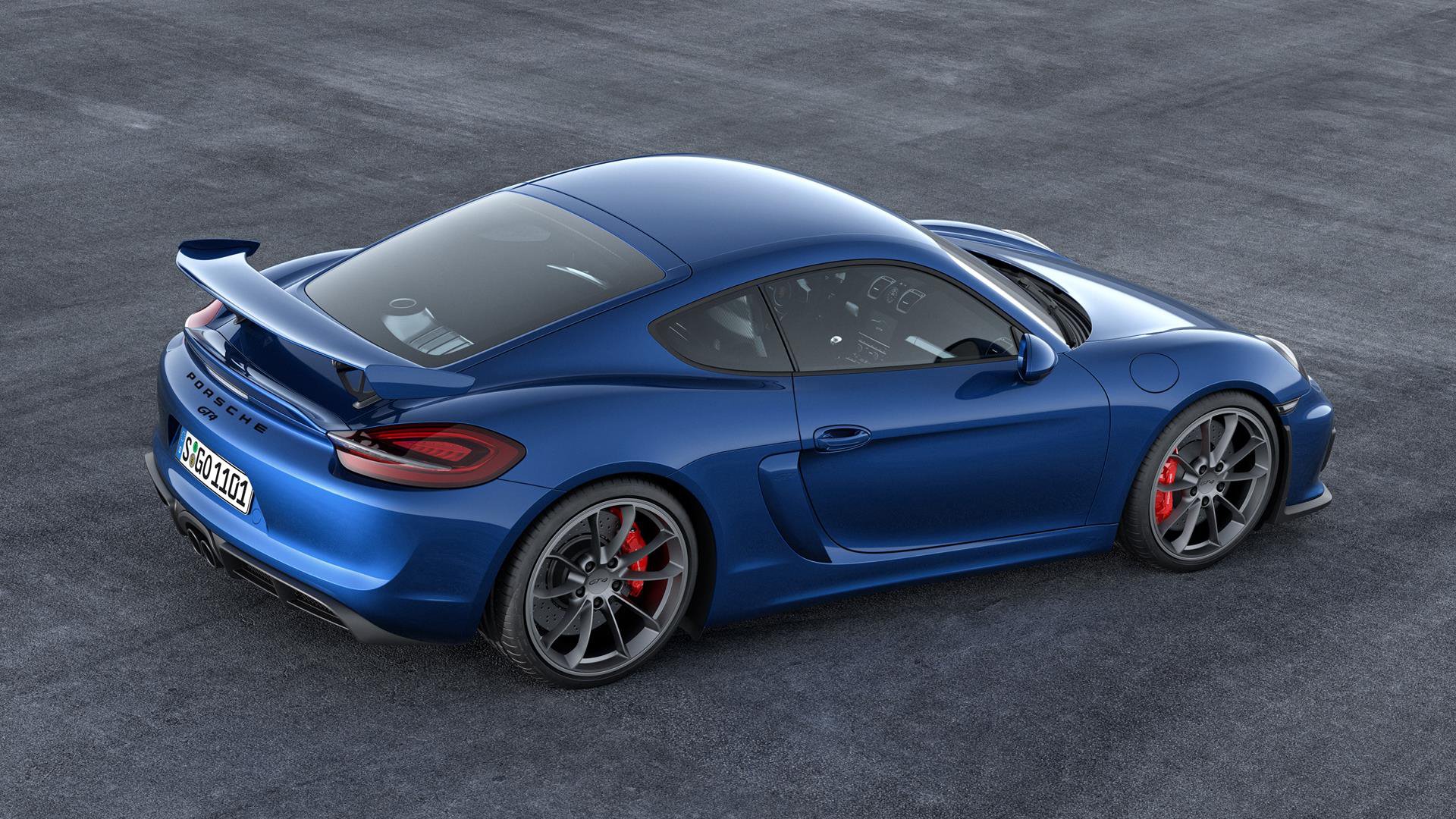 Blue Porsche Cayman GT4 on asphalt — HD PC desktop wallpaper showing a rear three-quarter view of the sporty vehicle.