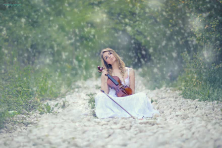 A woman sits on a snowy path, holding a violin, her eyes cast upward thoughtfully. Snow gently falls around her, creating a serene and contemplative mood. HD desktop wallpaper and background.