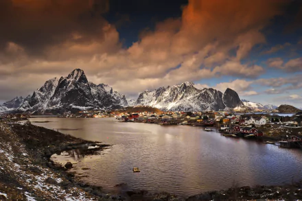 Scenic sunset over the Lofoten Islands in Norway, featuring dramatic mountains and a charming village reflected in tranquil waters, creating an inviting landscape backdrop.