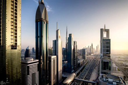 HD desktop wallpaper of Dubai's Sheikh Zayed Avenue, showcasing towering skyscrapers like the Rose Tower in a bustling cityscape with dynamic traffic and a monorail in the megapolis of the United Arab Emirates.