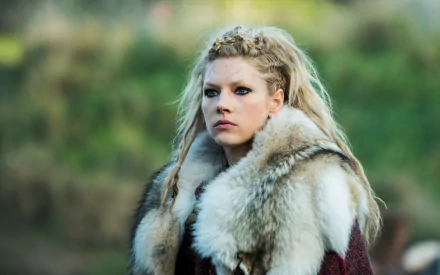 Lagertha, portrayed by Canadian actress Katheryn Winnick, gazes intensely in this HD wallpaper from the TV show Vikings, showcasing her striking blue eyes and blonde hair.