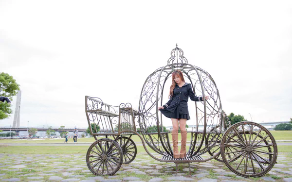 Asian Taiwanese model Xiao Xi poses in boots and a black outfit on a decorative carriage, captured in a 4K Ultra HD desktop wallpaper background.