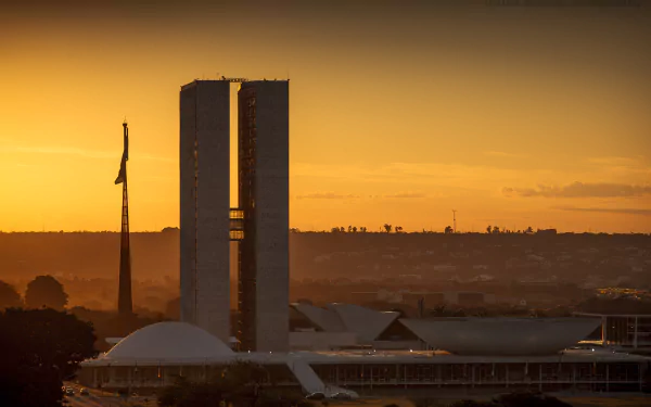 Sunrise over Brasília's modernist National Congress towers and domes, bathed in golden light — HD desktop wallpaper.