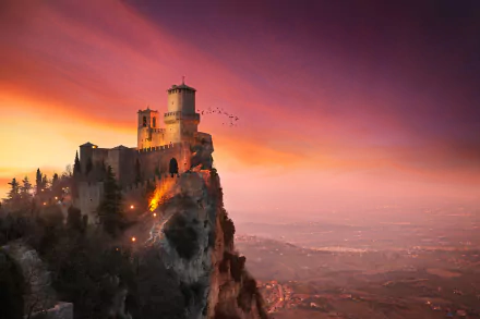 Sunset sky illuminates the Fortress of Guaita, a historic man-made fortress perched on a cliff in San Marino, captured in stunning HD for a desktop wallpaper.