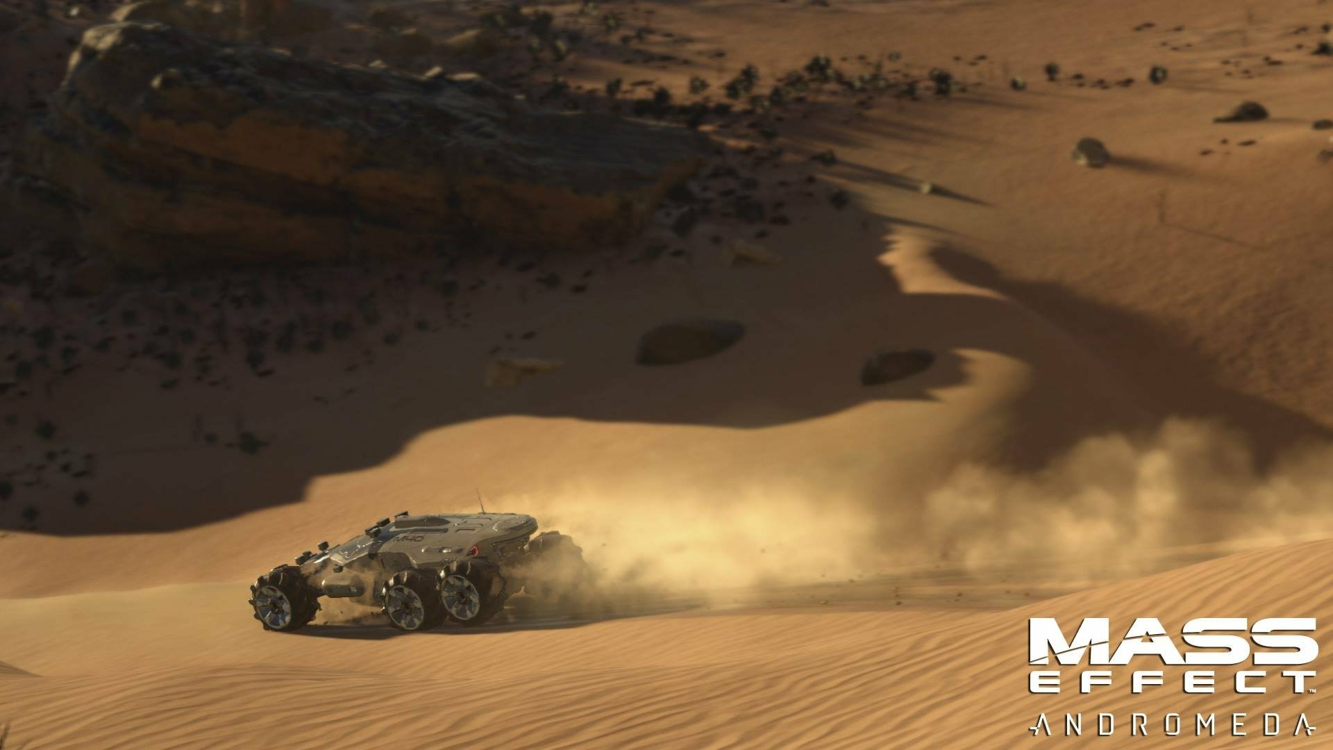 A high-definition wallpaper from Mass Effect: Andromeda, showcasing a vehicle traversing a sandy landscape, surrounded by rugged terrain and stirring up dust.
