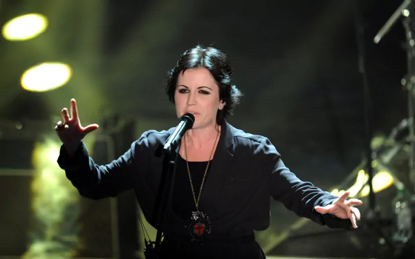 Female rock singer performing passionately on stage with dramatic lighting; music-themed 2K Quad HD PC desktop wallpaper/background.