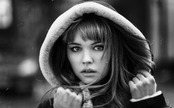 Black and white HD desktop wallpaper featuring a woman wearing a hood in the snow, tagged with model and Anastasiya Scheglova.