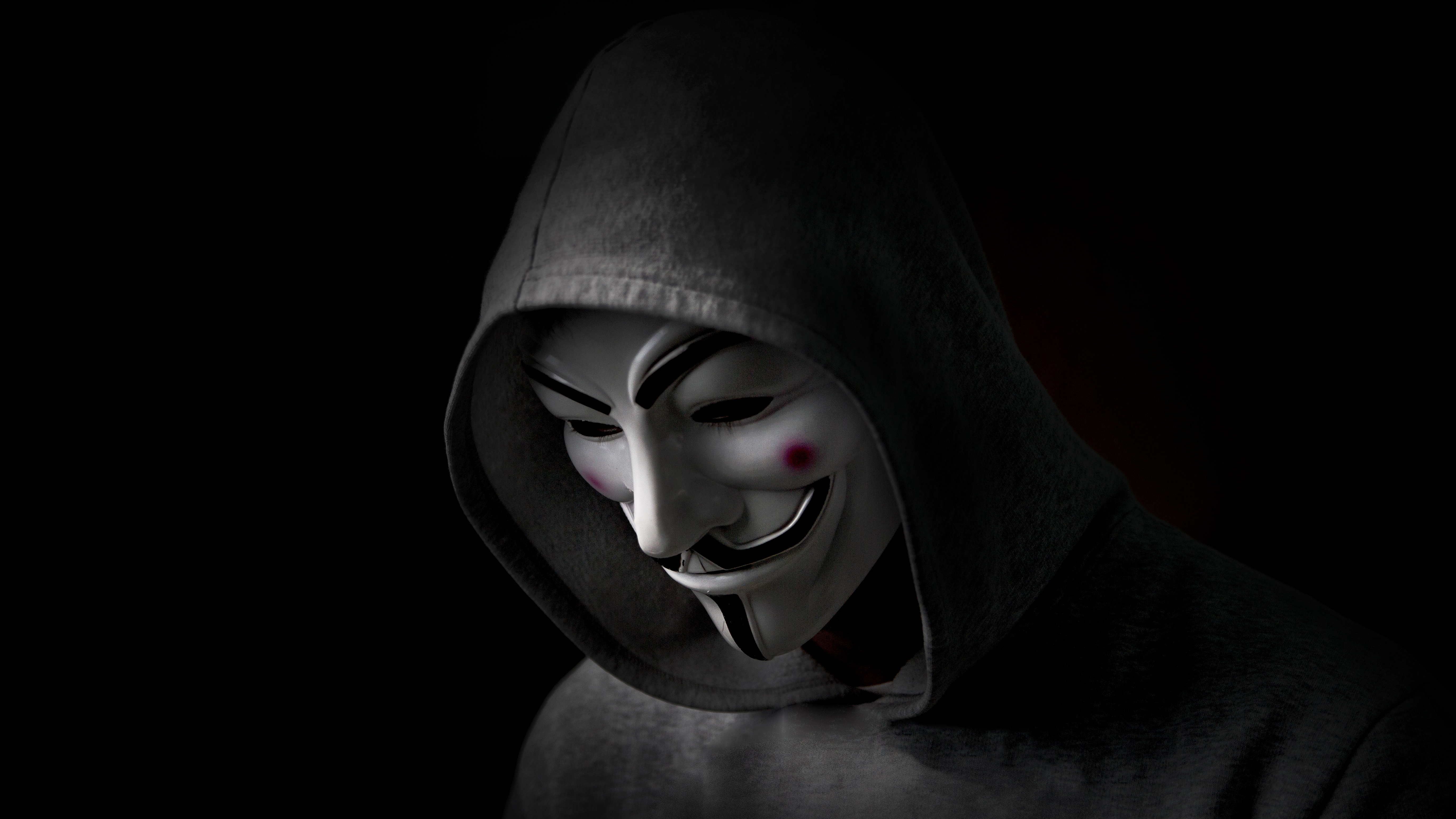 Hooded anonymous in a Guy Fawkes mask