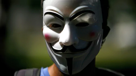 HD desktop wallpaper featuring a person wearing the iconic Anonymous Guy Fawkes mask, emphasizing themes of technology and anonymity.