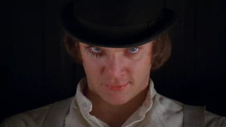 HD PC desktop wallpaper featuring a close-up of the main character from the movie A Clockwork Orange wearing a bowler hat and white collar against a dark background.