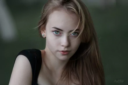 Close-up of a blonde woman with green eyes and earrings, set against a soft bokeh background, captured in HD for a PC desktop wallpaper.