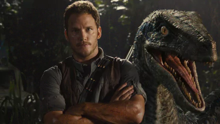 HD desktop wallpaper featuring Chris Pratt from the movie Jurassic World, standing with arms crossed beside a roaring dinosaur in a jungle setting.