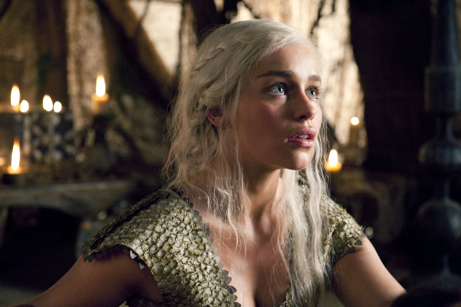 HD PC desktop wallpaper featuring Emilia Clarke as Daenerys Targaryen from the TV show Game of Thrones in a dimly lit medieval setting.