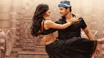 Mahesh Babu and Shruti Haasan dance together in a vibrant scene from the movie Srimanthudu, set against a colorful backdrop, creating a captivating HD wallpaper.