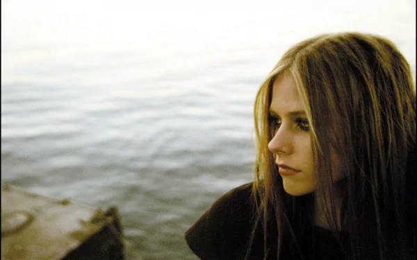 4K Ultra HD PC desktop wallpaper featuring a close-up of Avril Lavigne by the water, capturing a contemplative mood with soft natural lighting.