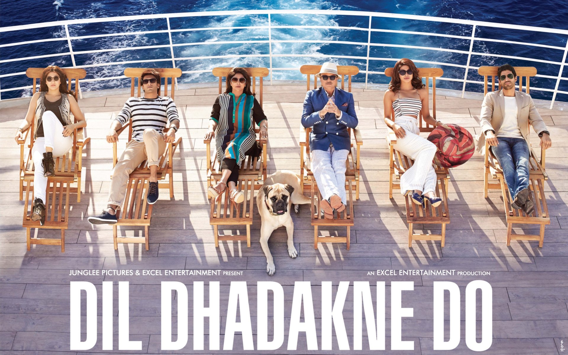 HD desktop wallpaper featuring the cast of the movie Dil Dhadakne Do relaxing on a yacht deck with a dog, set against a blue ocean background.