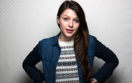 HD desktop wallpaper featuring celebrity Melissa Benoist, smiling confidently with a casual style, set against a light textured background.