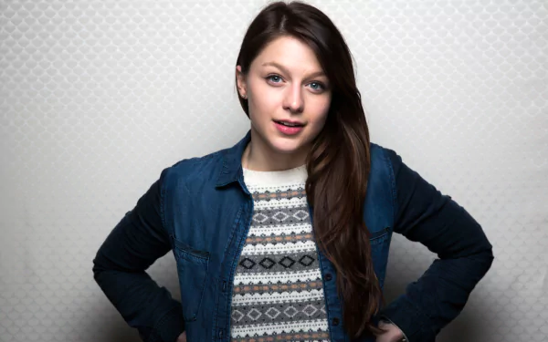 HD desktop wallpaper featuring celebrity Melissa Benoist, smiling confidently with a casual style, set against a light textured background.