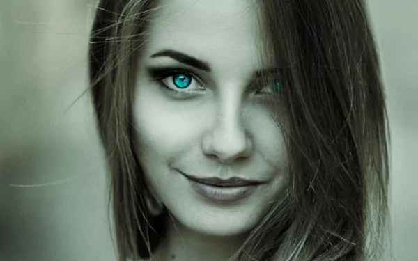 HD PC desktop wallpaper: close-up portrait of a woman with striking teal eyes and a subtle smile against a soft green-gray background.