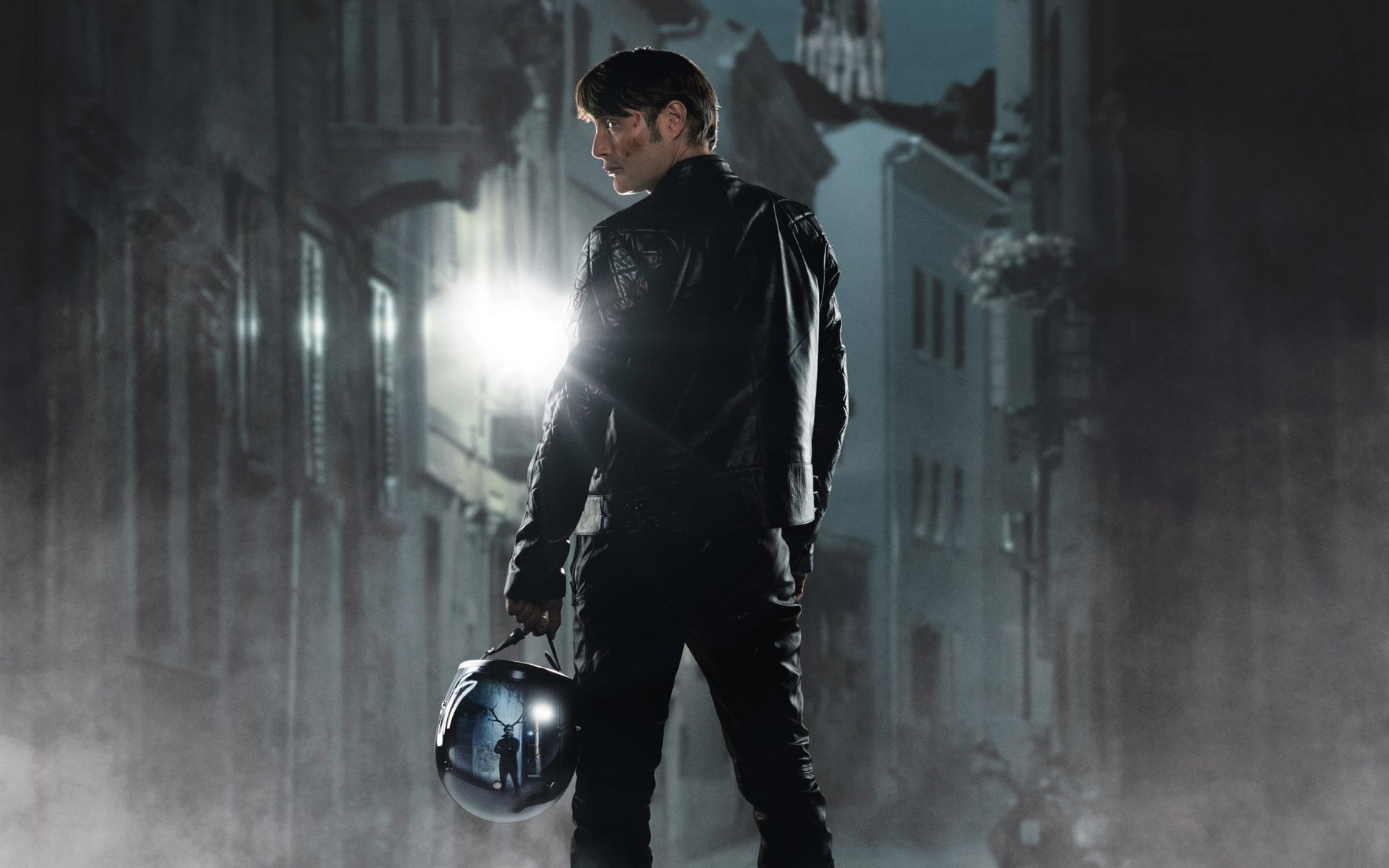 HD PC desktop wallpaper featuring a dark, atmospheric scene from the TV show Hannibal with a character holding a helmet in a foggy, dimly lit urban setting.