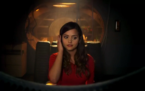 HD desktop wallpaper featuring Jenna Coleman as Clara Oswald from the TV show Doctor Who (2005), seated in a dimly lit, futuristic interior.