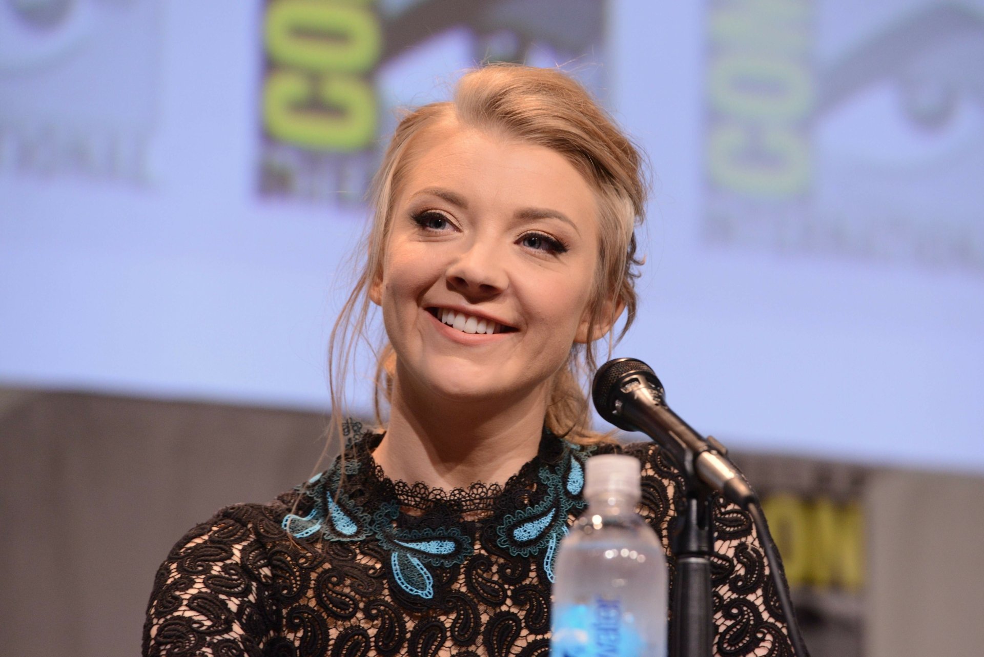 Blonde English actress Natalie Dormer smiles confidently during a panel discussion, captured in a 4K Ultra HD PC desktop wallpaper.